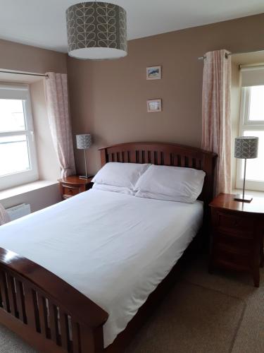 um quarto com uma cama grande e 2 janelas em Snooze Apartments em Newcastle