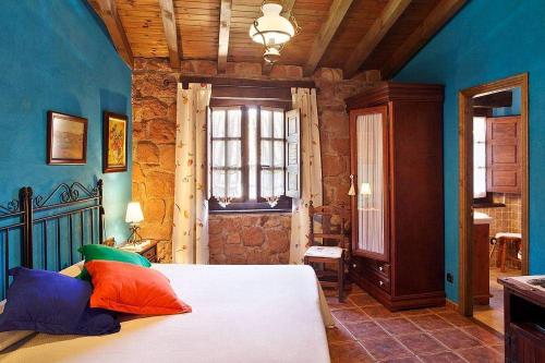 um quarto com uma cama com almofadas coloridas em Casa Contina em Cajide