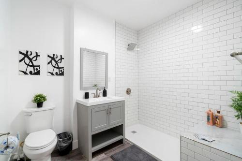 een witte badkamer met een toilet, een bad en een wastafel bij Prime & Convenient 2BR Apt in River North - Hubbard 2 in Chicago