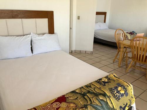 a bedroom with a bed and a table and chairs at Vista al mar y alberca privada en Sector Bahía in San Carlos