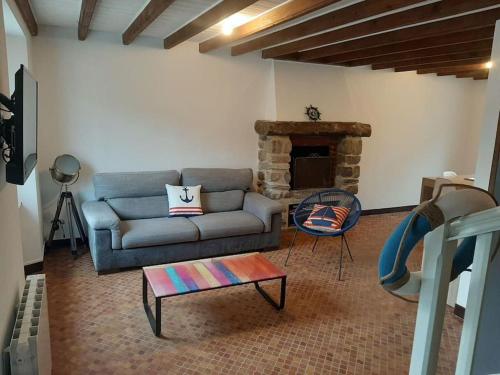 ein Wohnzimmer mit einem Sofa und einem Kamin in der Unterkunft La Perle Marine in Le Vivier-sur-Mer