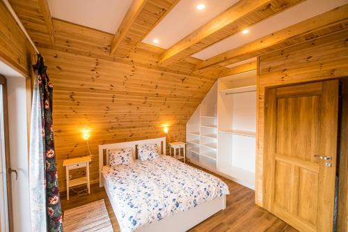a bedroom with a bed and a wooden ceiling at Kolorowe Karkonosze in Przesieka