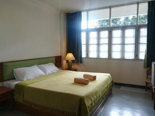 - une chambre avec un lit et une grande fenêtre dans l'établissement YMCA International Hotel Chiangrai, à Ban Fang Min