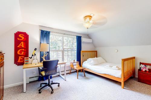1 dormitorio con cama, escritorio y silla en Pleasant Beach Road Retreat, en South Thomaston