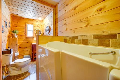 a bathroom with a tub and a toilet at Riverfront Hadley Getaway with Fire Pit and Boat Dock! in Lake Luzerne