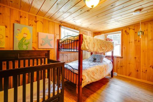 a bedroom with two bunk beds in a cabin at Riverfront Hadley Getaway with Fire Pit and Boat Dock! in Lake Luzerne