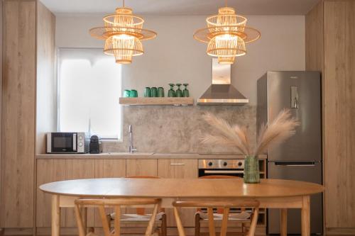 eine Küche mit einem Holztisch mit Stühlen und Lampen in der Unterkunft Vallia Suites-Green Luxury Suite A3 in Nafpaktos