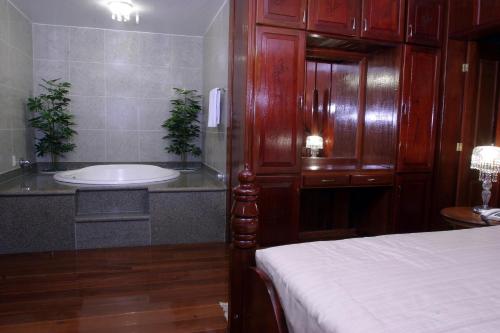 uma casa de banho com uma banheira, uma cama e um lavatório. em Hotel Du Lac Macaé em Macaé