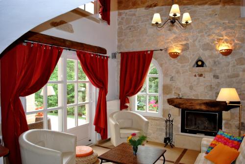 a living room with red curtains and a fireplace at Rock House's Villa Melody in Plataniás
