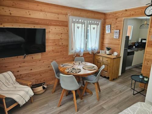 a dining room with a table and chairs and a television at Studio à 100 mètres du départ des pistes de ski in La Salle-les-Alpes