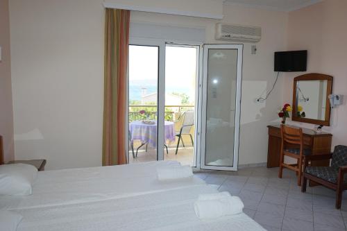 a hotel room with a bed and a sliding glass door at Manos in Megás Limniónas