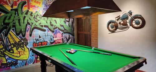 a pool table in front of a wall with graffiti at Villa Ecotiva in Puducherry