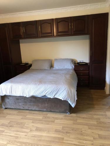 a bedroom with a large bed with wooden cabinets at Gernant in Llanrug