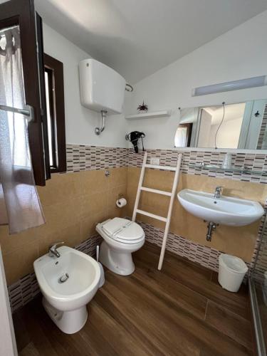 łazienka z 2 toaletami i umywalką w obiekcie Il Tramonto w mieście Giba