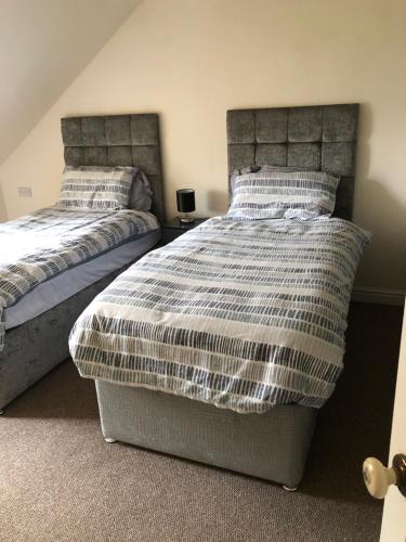 two beds sitting next to each other in a bedroom at Gernant in Llanrug