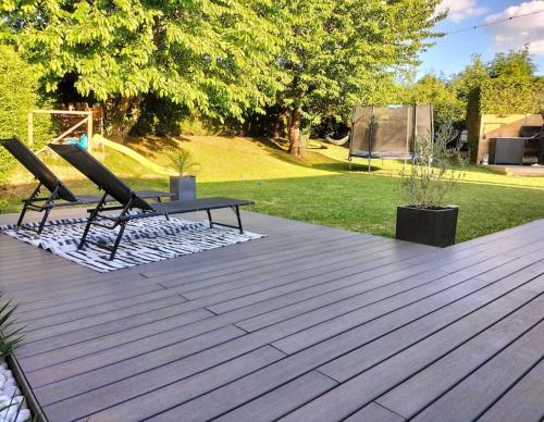 two chairs and a picnic table on a wooden deck at Maison 100m² proche sites JO2024 in Élancourt