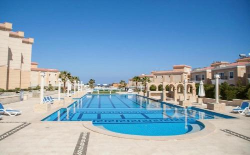 a swimming pool in a resort with chairs at SELENA BAY RESORT HURGHADa in Hurghada