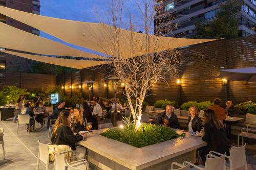 a group of people sitting at tables in a restaurant at Ola Santiago Providencia, Tapestry Collection by Hilton in Santiago