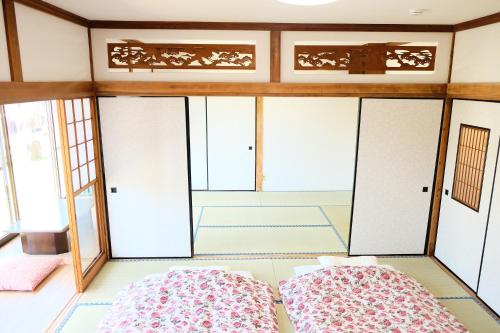 two beds in a room with windows at Forest-inn Kasama in Kasama