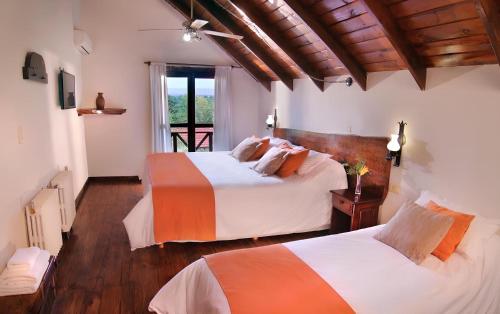 sypialnia z 2 łóżkami i oknem w obiekcie Aldea de los Pajaros w mieście Villa General Belgrano
