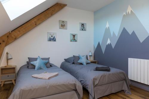 two beds in a bedroom with mountains painted on the wall at T4 Meublé de 105m2 axe Annecy-Geneve in Saint-Martin-Bellevue