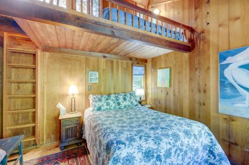 1 dormitorio con 1 cama en una cabaña de madera en Enchanting Arch Cape Retreat with Hot Tub, Fireplace, en Arch Cape