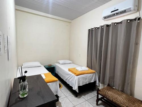 une salle d'hôpital avec deux lits et une table dans l'établissement HOSTEL GIRASSOL, à Ponte Alta do Tocantins