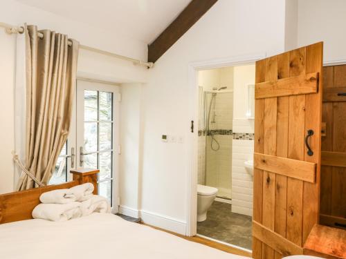 ein Schlafzimmer mit einem Bett und einer Dusche sowie ein Badezimmer in der Unterkunft Beudy'r Wennol in Caernarfon