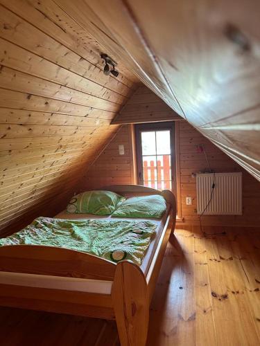 a bedroom with a bed in a wooden room at Zielkowa Ostoja in Niesiołowice
