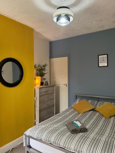a bedroom with a bed and a yellow wall at THE PORT House in Birmingham