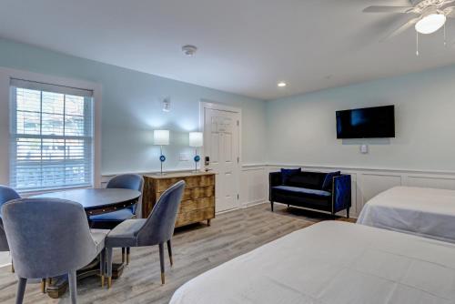 a hotel room with a bed and a table and chairs at Loggerhead Inn and Suites in Surf City