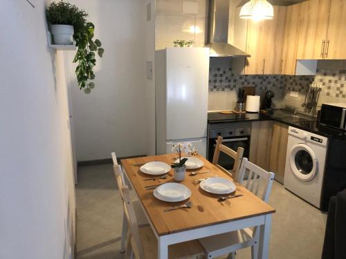 cocina con mesa de madera con sillas y comedor en Como en casa, en Parla