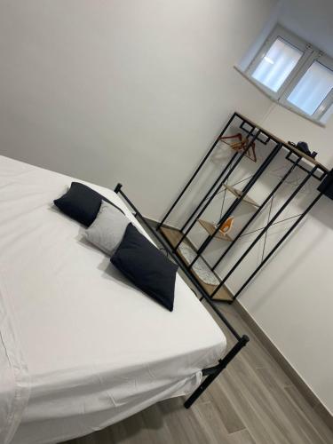 - un lit blanc avec des oreillers noirs dans une chambre dans l'établissement Rossella Silver House, à Minturno
