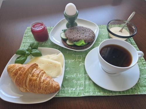 a table with two plates of food and a cup of coffee at Big room with balcony in a shared apartment in the center of Kerava in Kerava