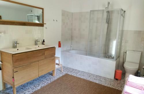 een badkamer met een bad, een wastafel en een douche bij Maison Seillans les Fontaines in Seillans