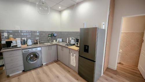 a kitchen with a refrigerator and a washing machine at Kaneel Suiker in Paarl