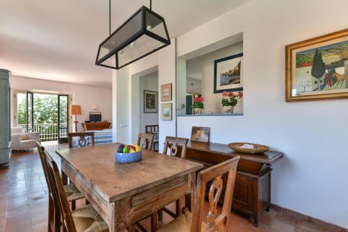 a dining room and living room with a table and chairs at Villa Le Tre Palme in Porto Azzurro
