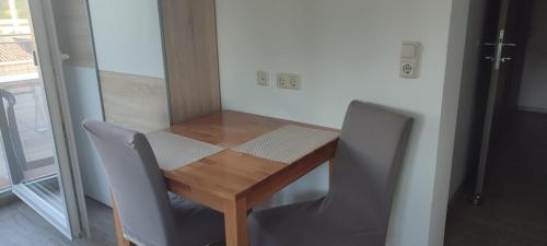 a table with two chairs and a wooden table and a table at Helis Gästezimmer in Kirchbach in Steiermark