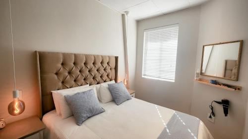 a bedroom with a large bed with a large headboard at Kaneel Suiker in Paarl