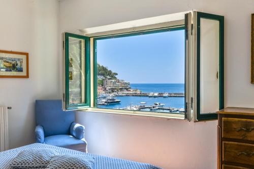 a bedroom with a window with a view of the ocean at Villa Le Tre Palme in Porto Azzurro