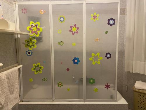 a shower with flowers stickers on the wall at Villa Maria in Reggio di Calabria