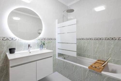 a white bathroom with a sink and a mirror at Braga 3BR Wonder by LovelyStay in Braga
