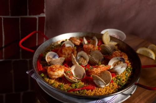 a pan of food with seafood and rice on a table at 21c Museum Hotel St Louis in Saint Louis