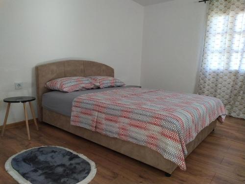 sypialnia z łóżkiem z kocem i stołem w obiekcie Olive House w Petrovacu na Moru