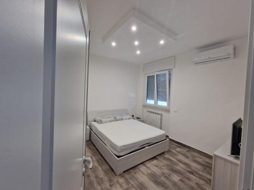ein kleines Schlafzimmer mit einem Bett und einem Fenster in der Unterkunft the suite on the beach in Torvaianica