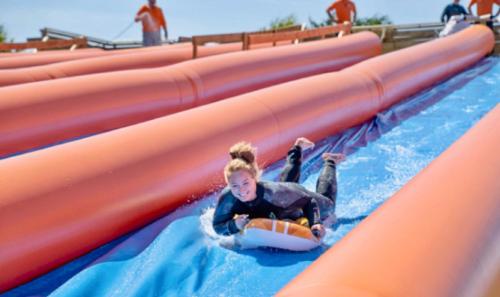 a young girl slides down a water slide at a water park at Springer Villa, 2 bed, Newquay in Newquay