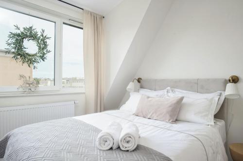 um quarto com uma cama branca e toalhas em LUNA Apartment em Toruń