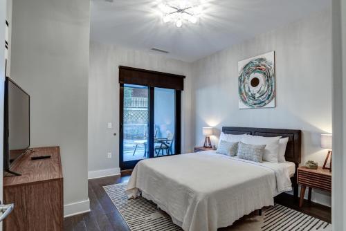a bedroom with a bed and a flat screen tv at Downtown Condo City Center in Asheville
