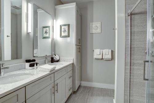 a white bathroom with a sink and a shower at Downtown Condo City Center in Asheville