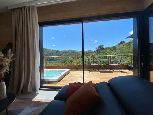 - un salon avec un canapé bleu et une grande porte coulissante en verre dans l'établissement L'Eden des Cévennes, à Le Pont-de-Montvert